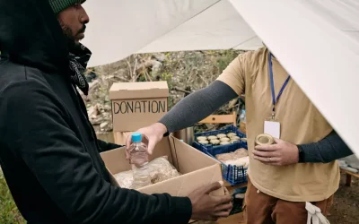 young-refugee-man-holding-box-while-volunteer-putt-2021-10-20-03-17-47-utc.webp